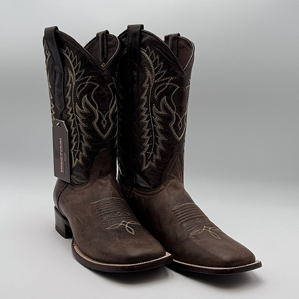 Pair of dark brown cowboy boots with detailed stitching and classic shape.